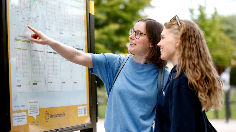 Två tjejer som kollar på linjekartan vid universitet
