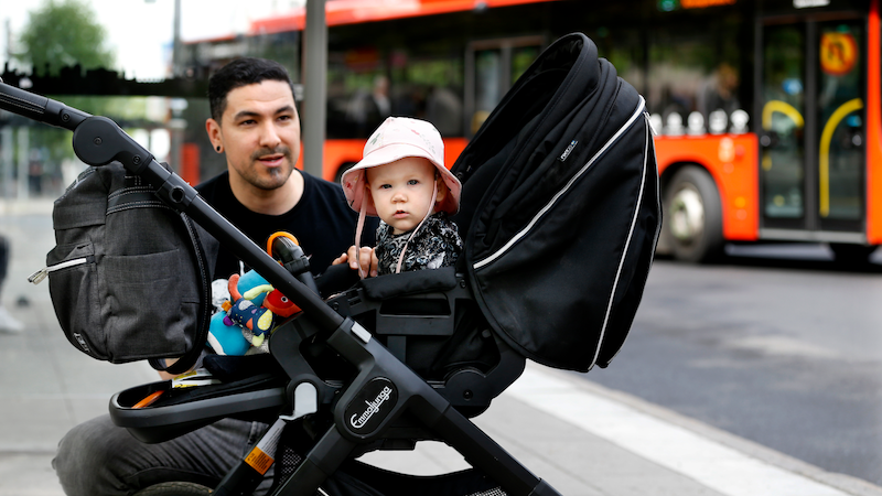 Far och dotter som väntar på bussen
