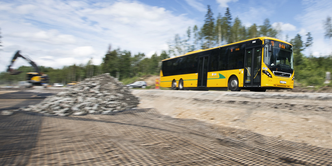 Gul buss kör på en väg.