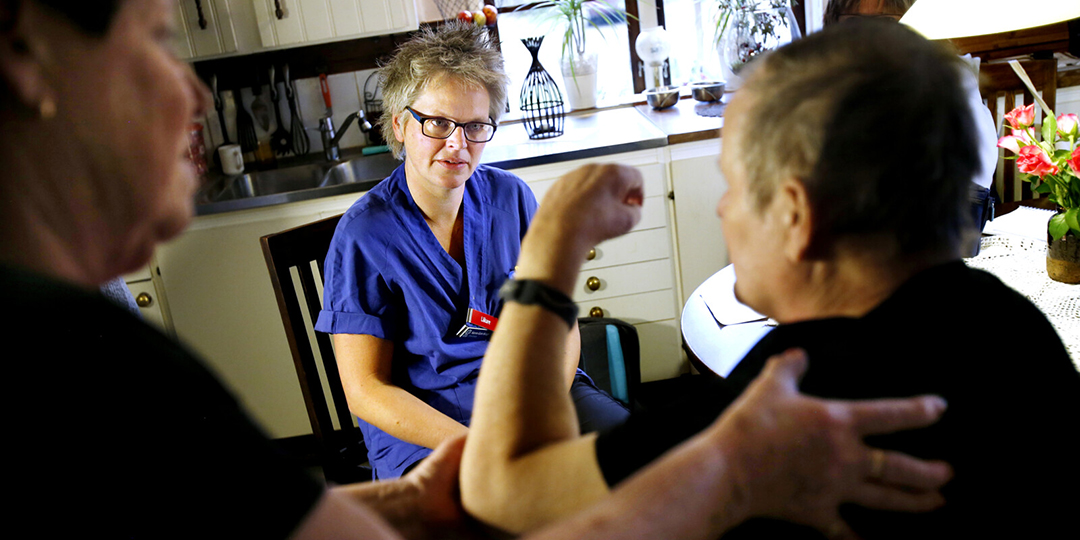Läkare besöker patient hemma i köket.