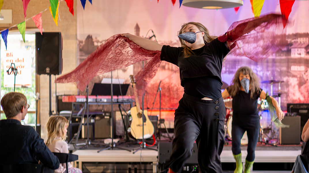 Person dansar med näbb och vingar av tyll. 