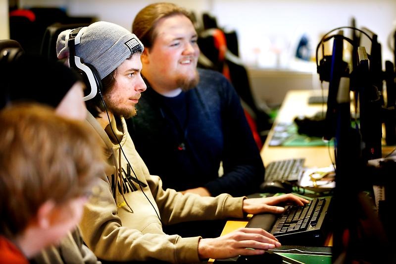 Tre personer framför datorskärmar
