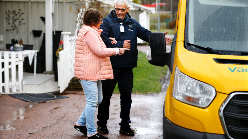 Förare hjälper kvinna ombord på servicetrafikfordon