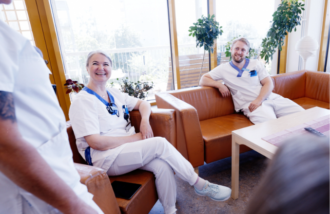 Två vårdpersonal sitter i en soffa 