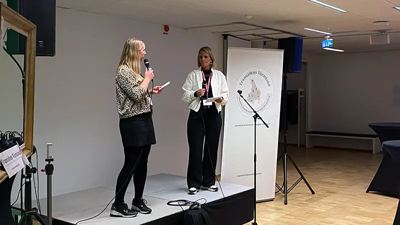 Två kvinnor på en liten scen.