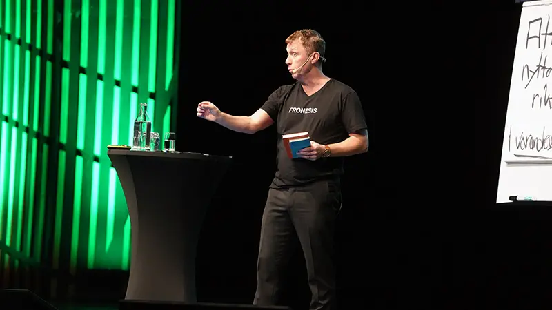 En man i svart t-shirt på en scen.