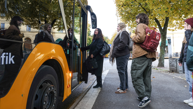 Personer går på en buss. 