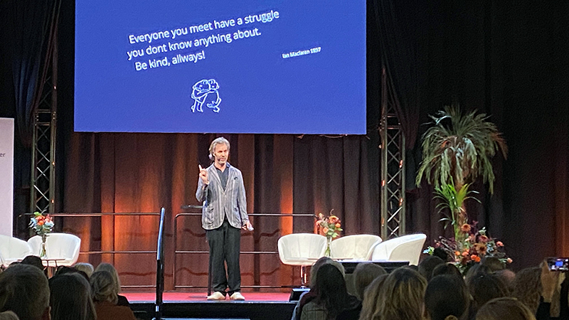 En person på en scen som föreläser. 