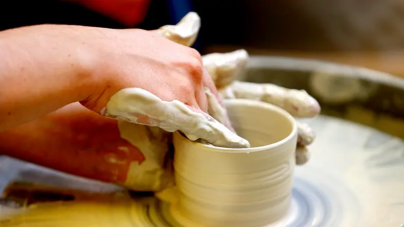 Närbild på händer som drejar. 