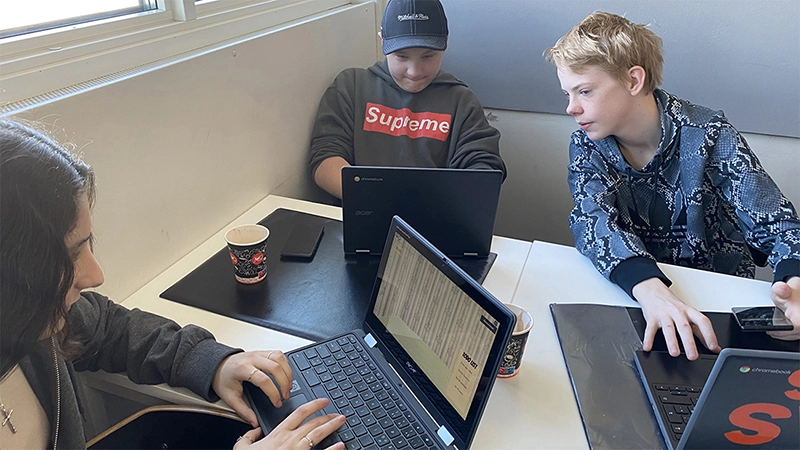 Tre skolelever vid sina datorer.