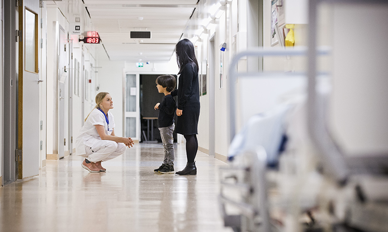 Mamma med barn pratar med sjuksköterska
