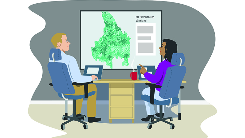 Två personer sitter vide ett bord och tittar på en Värmlandskarta.