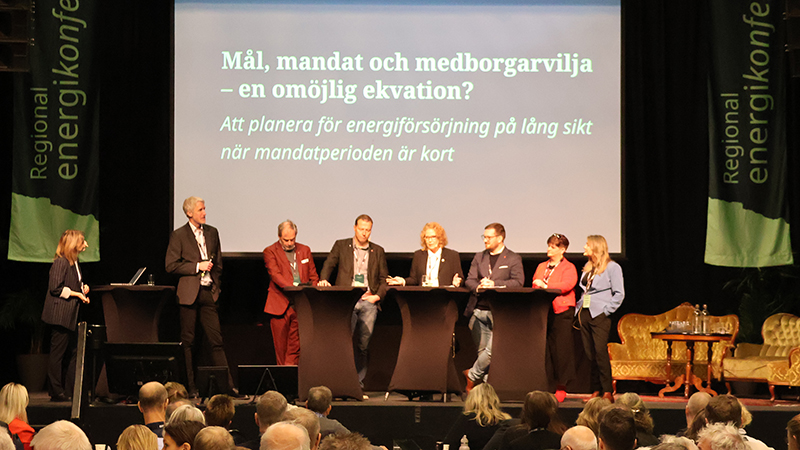 Åtta personer står på en scen.