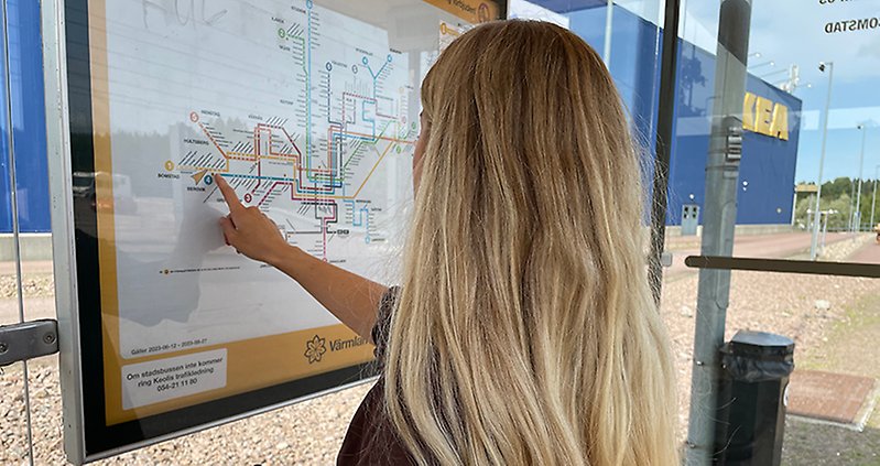 Person kollar linjenätskartan på hållplatsen Ikea.